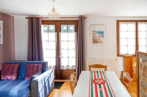 un soggiorno con un divano blu e un tavolo di Appartement Txikia ad Amotz