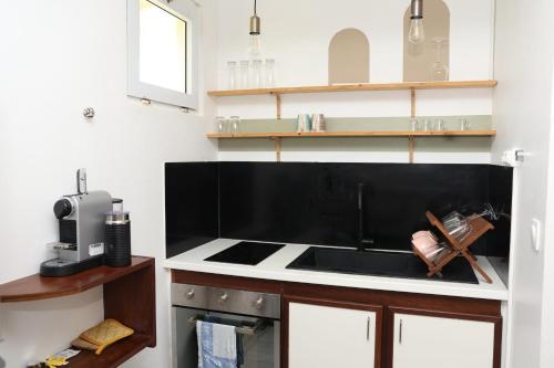 a kitchen with a black and white stove top oven at Kaz Mboa Vista - Rémire-Montjoly in Montjoly