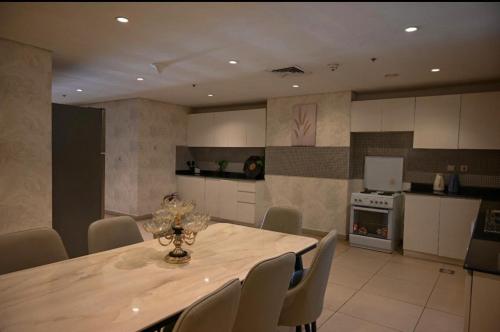 una cucina con un tavolo e sedie in una stanza di شقة في برج داماك a Gedda