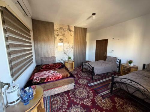 a room with two beds and a table in a room at Eman house in Wadi Musa