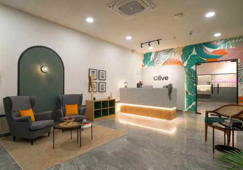 a lobby with two chairs and a table and a counter at Olive Hotel Hitec City by Embassy Group in Hyderabad