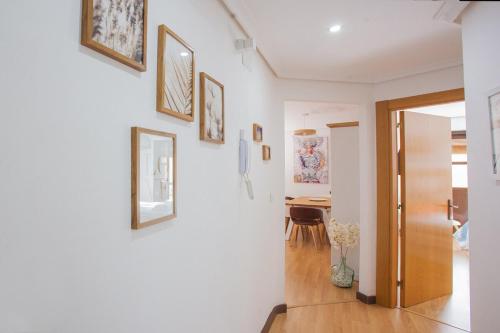 a hallway with a white wall with pictures on it at Castillo Buenavista in Ponferrada
