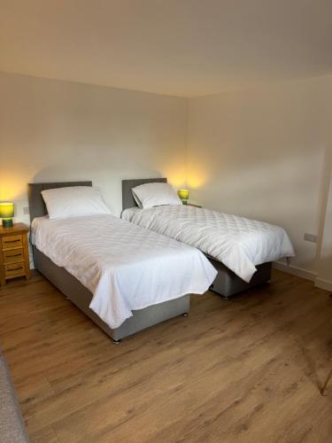 2 Einzelbetten in einem Zimmer mit Holzböden in der Unterkunft Poets View - Studio in Honington, Suffolk in Honington