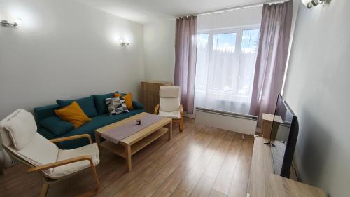 a living room with a blue couch and a table at Sun Stream Apartment in Pamporovo