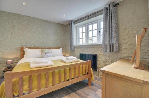 a bedroom with a wooden bed and a window at Hideaway in Appledore