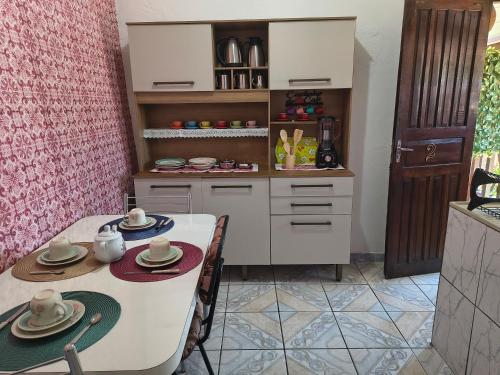 een keuken met een tafel en stoelen en een aanrecht bij Chalé da Elba 01 Ilhabela in Ilhabela