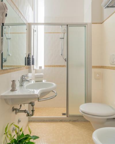 a bathroom with two sinks and a toilet at Acapulco Hotel in Cattolica