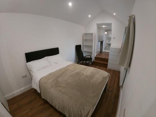 ein Schlafzimmer mit einem Bett und einem Stuhl darin in der Unterkunft Woodrow close in Perivale
