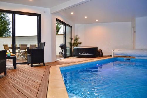 ein Wohnzimmer mit einem Pool und ein Schlafzimmer in der Unterkunft A l oree du bois piscine intérieure privée sans vis à vis in Auvilliers