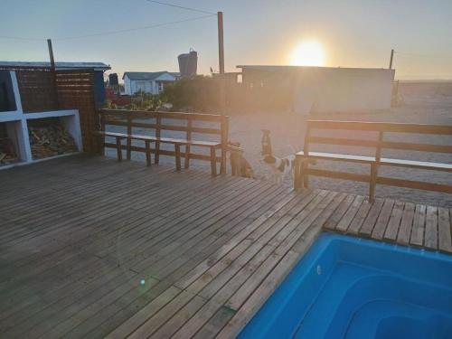 a deck with two benches and a swimming pool at El Fortín de los Choros, un descanso para la familia in Los Choros