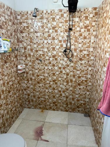 um banheiro com chuveiro revestido de azulejos com câmera em Casa completa com dois quartos e uma suíte master, localizada no bairro Alphaville Fazendinha em Macapá