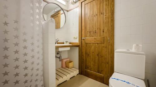 bagno con servizi igienici e porta in legno di Chez Bonheur a Osséja
