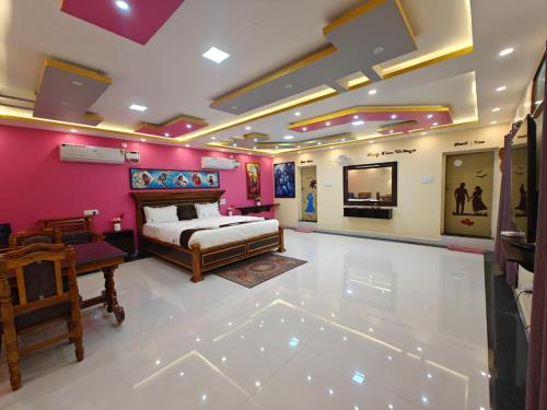 Schlafzimmer mit rosa Wänden, einem Bett und einem TV in der Unterkunft Malathi Residency in Arumuganeri