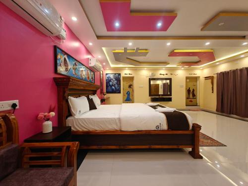 ein Schlafzimmer mit einem großen Bett und rosa Wänden in der Unterkunft Malathi Residency in Arumuganeri