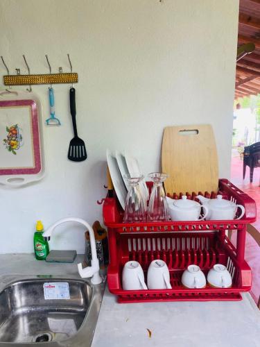 a red dish drying rack next to a kitchen sink at Perfect Home Mirissa in Mirissa