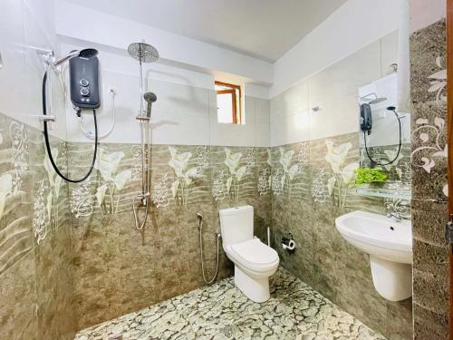 ein Badezimmer mit Dusche, Toilette und Waschbecken in der Unterkunft Ocean's Whisper in Tangalle