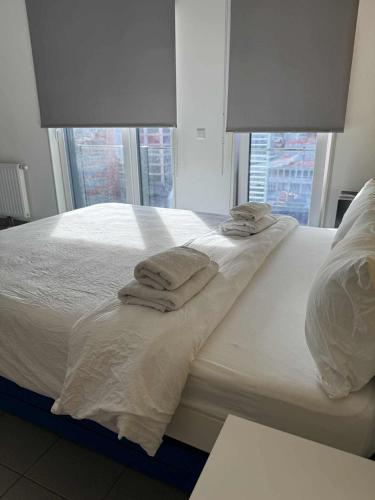 a bed with white sheets and towels on it at Modern studio Belval in Esch-sur-Alzette