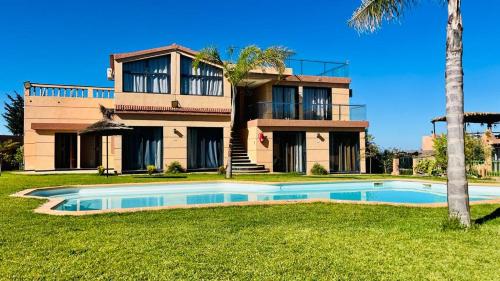 ein Haus mit einem Swimmingpool davor in der Unterkunft Tynass Ferme in Fès