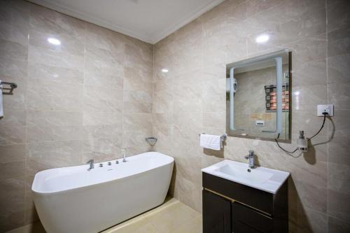 a bathroom with a white sink and a mirror at Luxury 4 bedroom Duplex with a pool in Mama