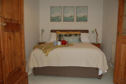 Un dormitorio con una cama con una tetera encima. en The Rest, en St Ives