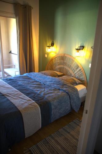 a bedroom with a bed with a blue comforter at Appartement Pont Royal vu lac in Mallemort