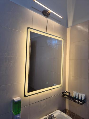 a bathroom with a mirror and a sink at The Palm Villa in Jaipur