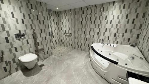 ein Bad mit einer Badewanne und einem WC. in der Unterkunft Quiet Dreams - Serviced Apartments King abdul Aziz Street Branch in Dschidda