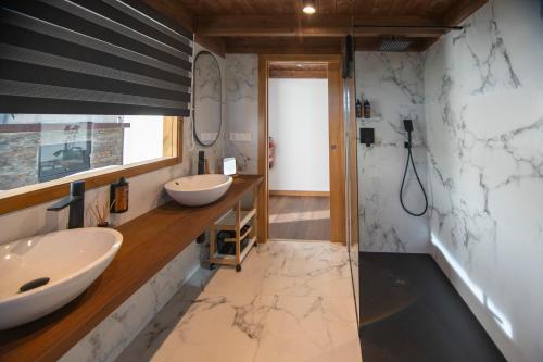 un bagno con due lavandini e una doccia di Cabanas do Chao 