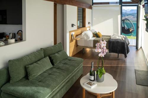 un soggiorno con divano verde e letto di Cabanas do Chao 