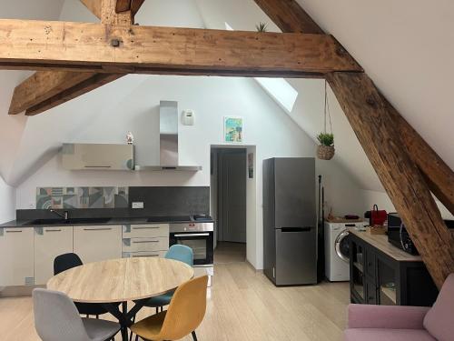 Una cocina con una mesa y sillas en una habitación. en Appartement vue sur le vieux port de Pornic, en Pornic