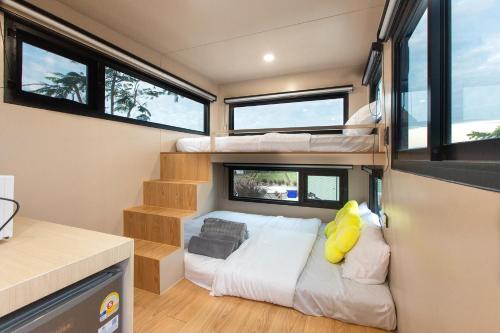 a bedroom with bunk beds in a tiny house at Mint camper car mine hills2 in Ban Mai