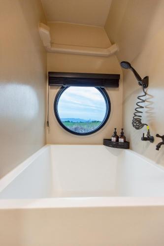 a small window in a small room with a white counter at Mint camper car mine hills2 in Ban Mai
