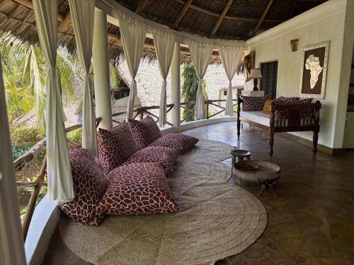 Villa Peponi Royale Watamu في واتامو: غرفة بها سرير دائري مع وسائد عليه