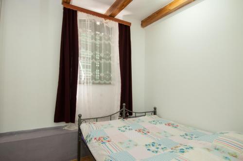a bedroom with a bed and a window at Apartment Tomic A-5 in Lovran