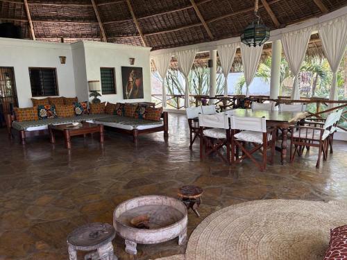 Villa Peponi Royale Watamu في واتامو: غرفة معيشة مع طاولة وكراسي وأريكة