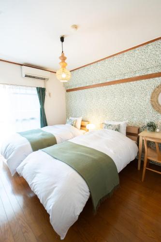 a room with three beds in a room at 海が見える隠れ家 -Tsukushi瀬戸内- in Takamatsu
