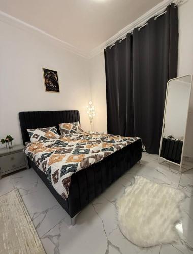 a bedroom with a bed with a comforter and a mirror at الريامي 4 in Sharjah