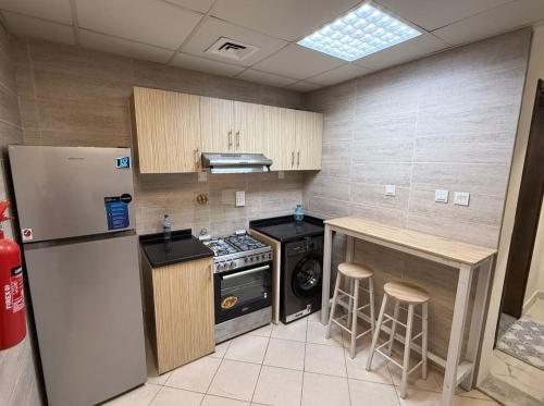 a kitchen with a refrigerator and a stove and a counter at الريامي 4 in Sharjah