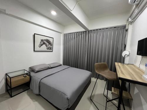 a bedroom with a bed and a desk with a desk at Hug14 Hotel in Ban Bang Toei (1)