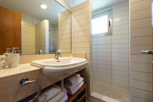 een badkamer met een wastafel en een spiegel bij Premium House with Private Heated Pool and Bbq in La Playa de Arguineguín