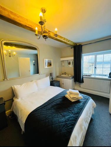 una camera da letto con un letto grande e una finestra di The Ilchester Arms ad Abbotsbury