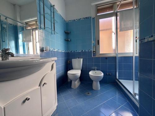 un bagno piastrellato blu con un water e un lavandino di Salerno a due passi dal mare a Salerno
