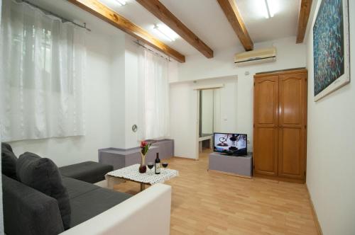 a living room with a couch and a tv at Apartment Tomic A-5 in Lovran