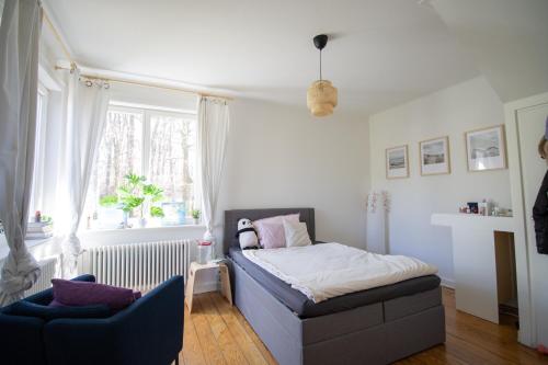 a small bedroom with a bed and a chair at Gästezimmer Volksdorf in Hamburg
