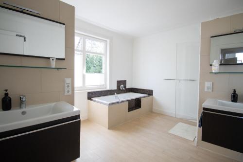 un baño con lavabo y bañera en Gästezimmer Volksdorf, en Hamburgo