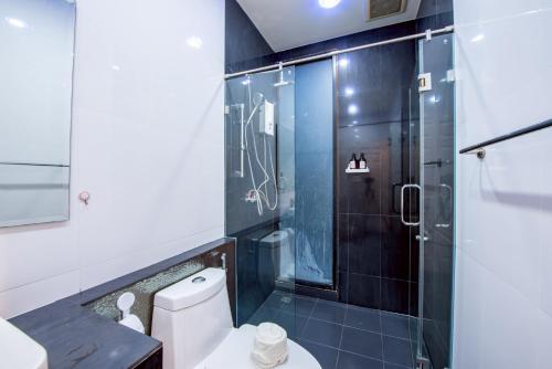 ein Badezimmer mit Toilette und Glasdusche in der Unterkunft Emery Pool Villa Pattaya in Ban Huai Yai