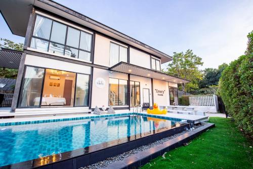a swimming pool in the backyard of a house at Emery Pool Villa Pattaya in Ban Huai Yai