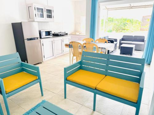 a kitchen with two blue chairs and a kitchen with a table at Devika villa in Triolet