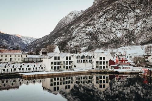 a town on the water in front of a mountain at Wangen Apartments in Aurland