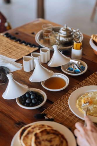 a wooden table with breakfast foods on it at Ô TALIA Hôtel and SPA in Nungwi